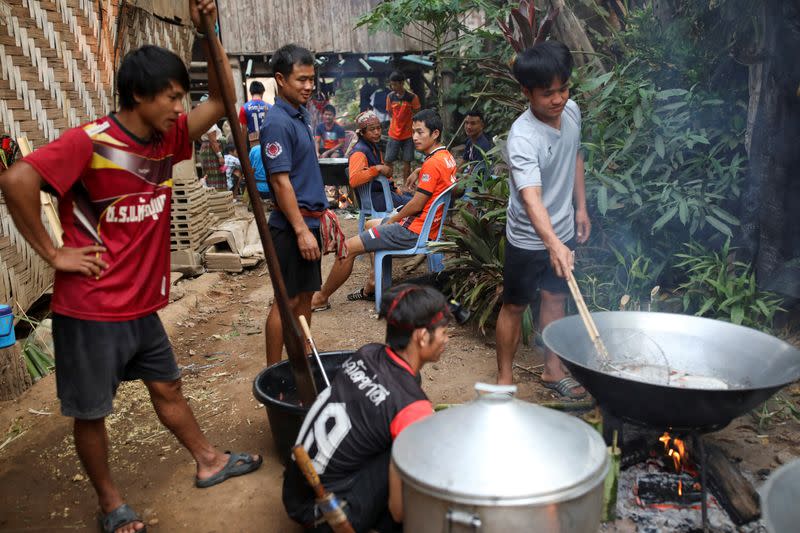 Men prepare food during a death anniversary in the Kayan village where people, who fled from Myanmar during the 1990s war between Myanmar's army and ethnic army groups, live in Mae Hong Son