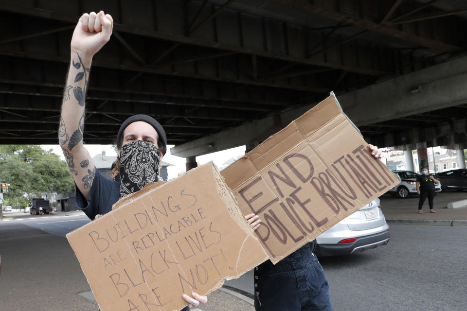 People protest the death of George Floyd, a handcuffed black man who died in the custody of the police in Minneapolis, rally on a street corner in New Orleans, Friday, May 29, 2020. (AP Photo/Gerald Herbert)