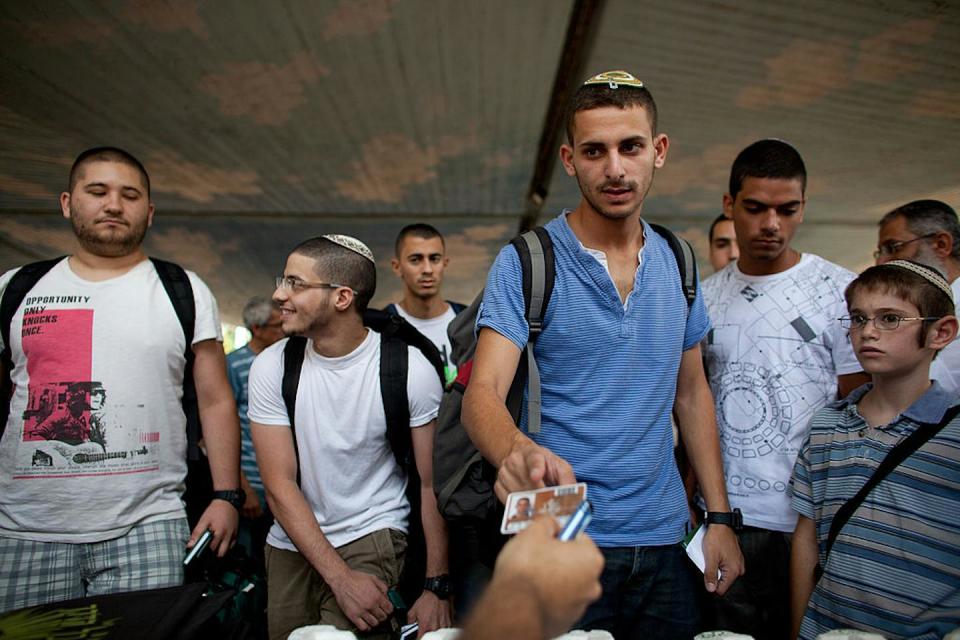 An Israeli recruit gets his army identification card after reporting for the draft on July 22, 2012, near Tel Aviv, Israel. <a href="https://www.gettyimages.com/detail/news-photo/an-israeli-army-recruit-gets-his-army-identification-card-news-photo/149047434?adppopup=true" rel="nofollow noopener" target="_blank" data-ylk="slk:Uriel Sinai/Getty Images;elm:context_link;itc:0;sec:content-canvas" class="link ">Uriel Sinai/Getty Images</a>