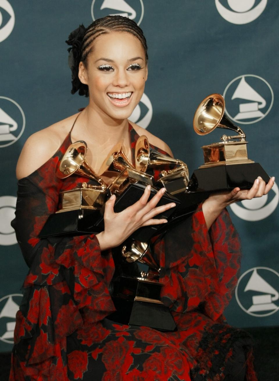 Alicia Keys balances her five Grammys at the 44th Annual Grammy Awards at the Staples Center in 2002.
