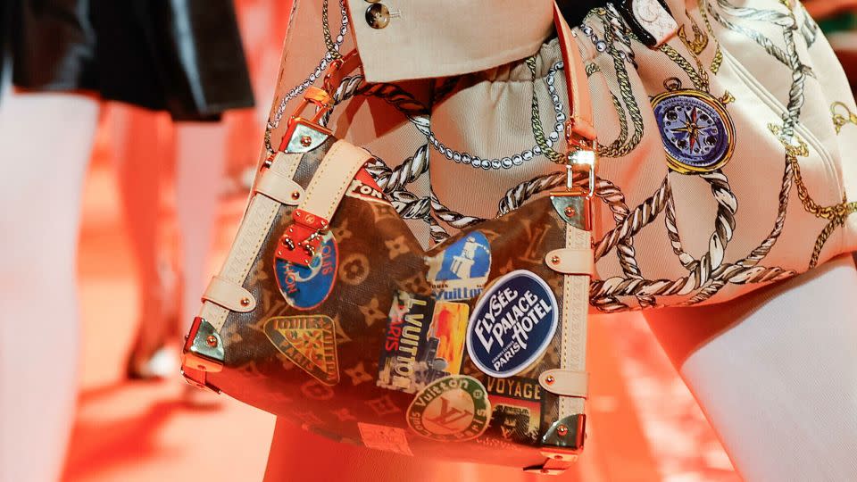 The latest Louis Vuitton collection looked to the power of travel, a theme perhaps most visible in this season's accessories — one bag was made in the shape the Arc de Triomphe, while others mimicked vintage luggage stickers. - Ik Aldama/picture-alliance/dpa/AP