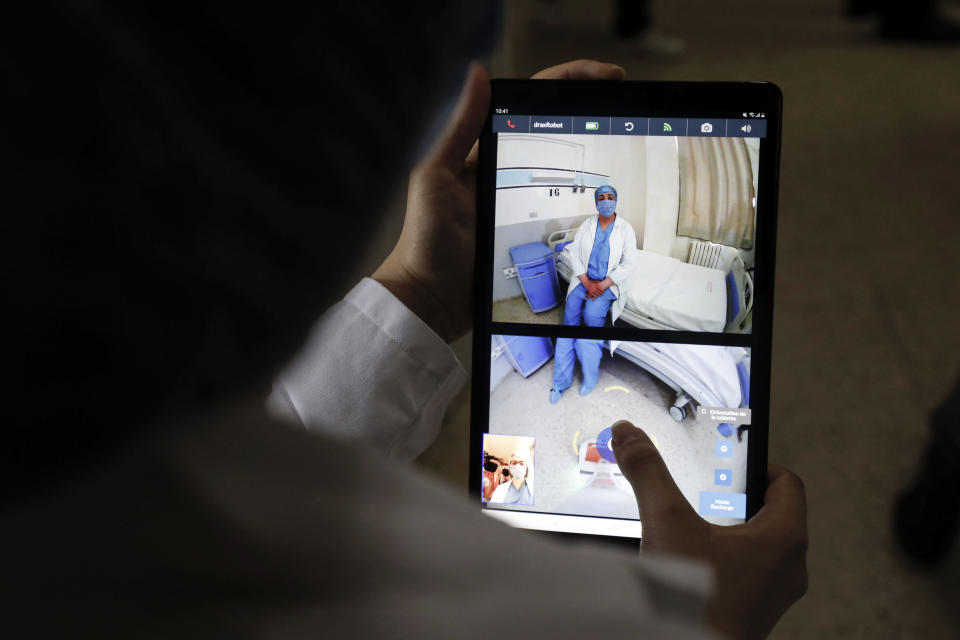 06 May 2020, Tunisia, Ariana: A doctor controls a robot with a mobile as she talks from distance to a coronavirus patient at the Abderrahmen Mami hospital, the robot was manufactured by a Tunisian company and was donated to the hospital to limit contact between medic staff and infected coronavirus (COVID-19) patients. Photo: Khaled Nasraoui/dpa (Photo by Khaled Nasraoui/picture alliance via Getty Images)