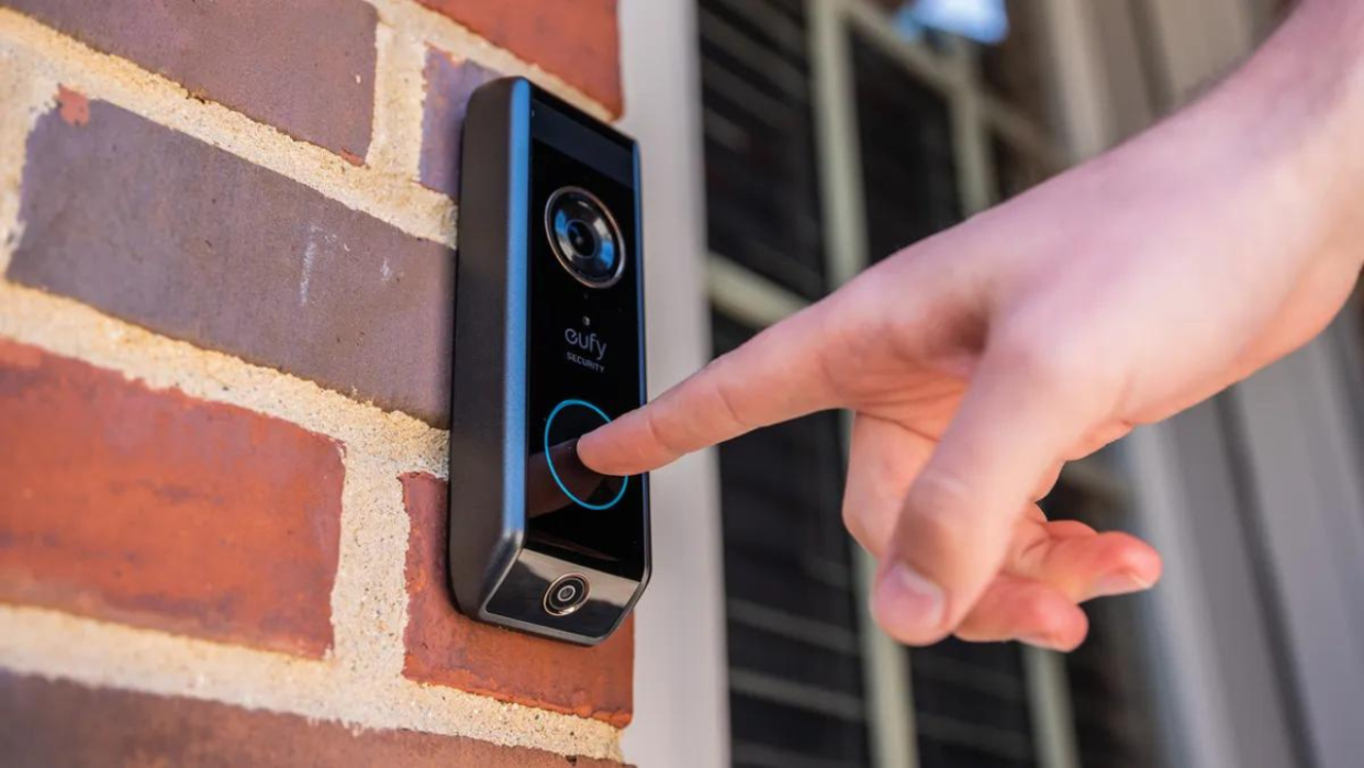  man pressing video doorbell 