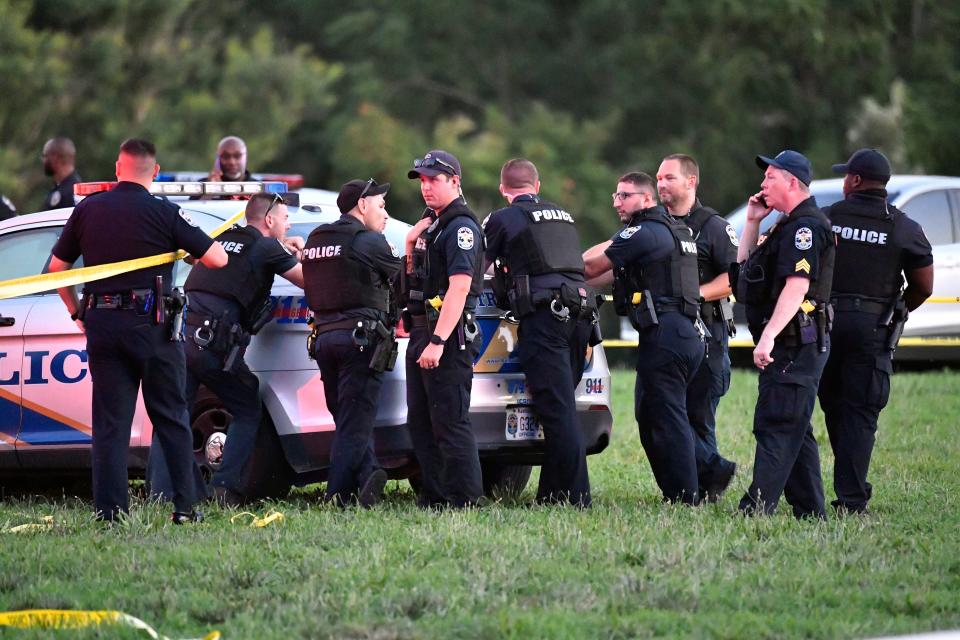 Police officers gather at the scene of a shootingat the baseball fields in Shawnee Park, Sunday, July 10 2022 in Louisville Ky.