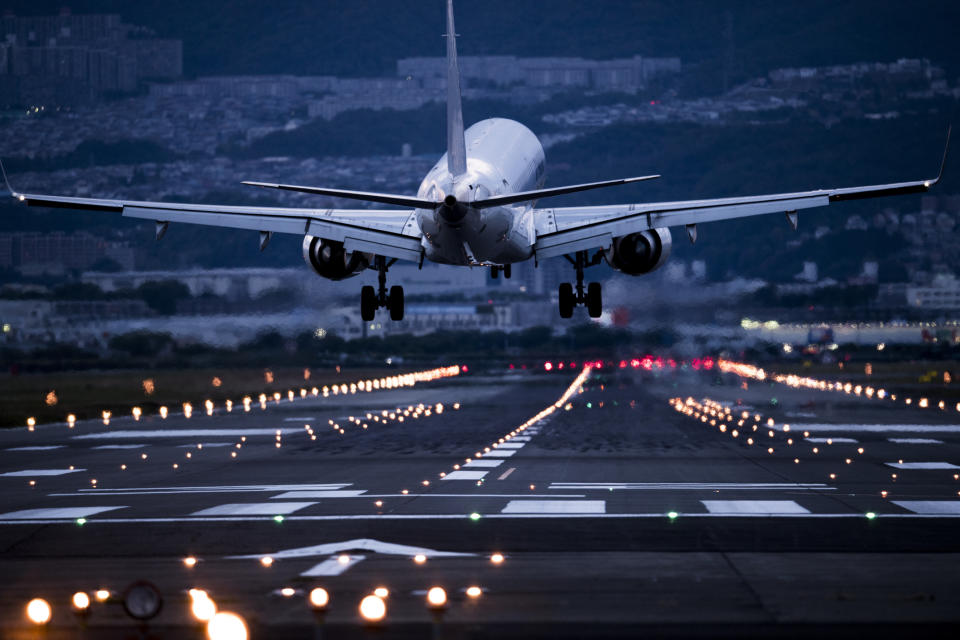 Airplane taking off from runway at dusk