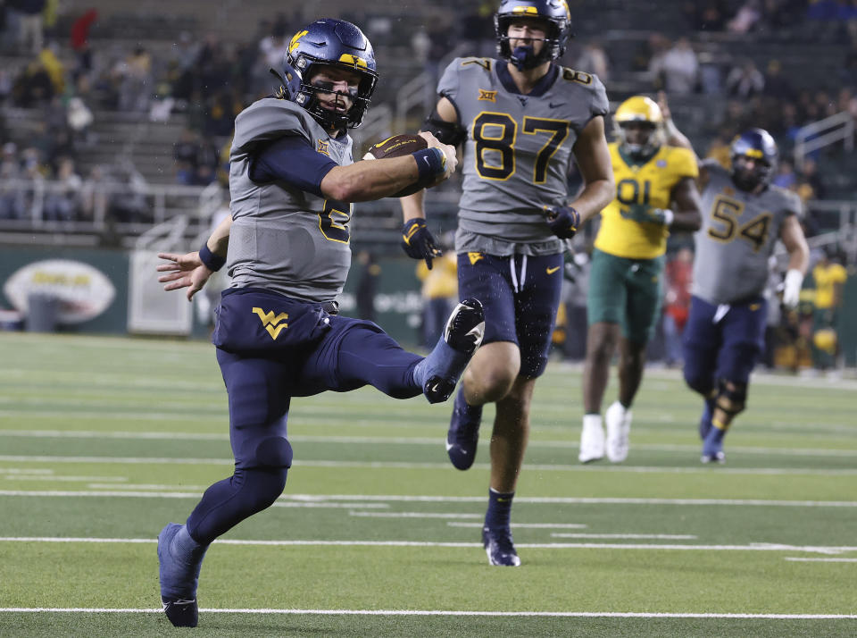 West Virginia quarterback Garrett Greene (6) dances into the end zone for a touchdown against Baylor in the first half of an NCAA college football game, Saturday, Nov. 25, 2023, in Waco, Texas. (Jerry Larson/Waco Tribune-Herald, via AP)