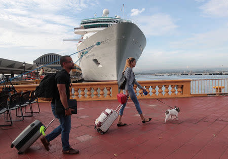 People carry their belongings after arriving along with other refugees onboard the Royal Caribbean's Majesty of the Seas cruise ship from St. Thomas, U.S. Virgin Islands, in San Juan, Puerto Rico September 14, 2017. REUTERS/Alvin Baez