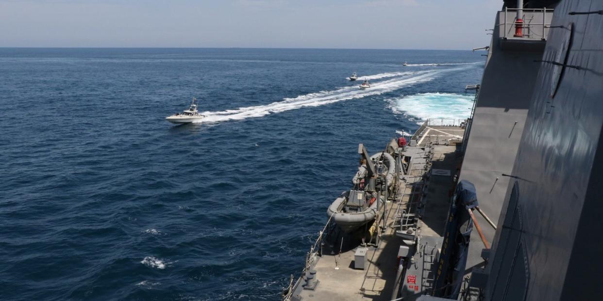 FILE PHOTO: Four Iranian Islamic Revolutionary Guard Corps Navy (IRGCN) vessels, some of several to maneuver in what the U.S. Navy says are "unsafe and unprofessional actions against U.S. Military ships by crossing the ships’ bows and sterns at close range" is seen next to the guided-missile destroyer USS Paul Hamilton in the Gulf April 15, 2020. U.S. Navy/Handout via REUTERS 