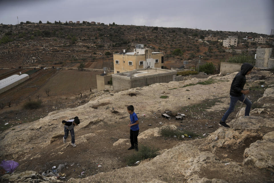 Palestinian boys scramble up a hill in a tense area near several unauthorized Israeli outposts on the edge of the Palestinian village of Qaryout in the northern West Bank, Sunday, Nov. 12, 2023. With the world’s attention focused on the fighting in Gaza, Israeli settler violence against Palestinians since Oct. 7 has surged to the highest levels ever recorded by the United Nations. Palestinians say this Israel-Hamas war has left them more scared and vulnerable than ever in recent memory. (AP Photo/Mahmoud Illean)