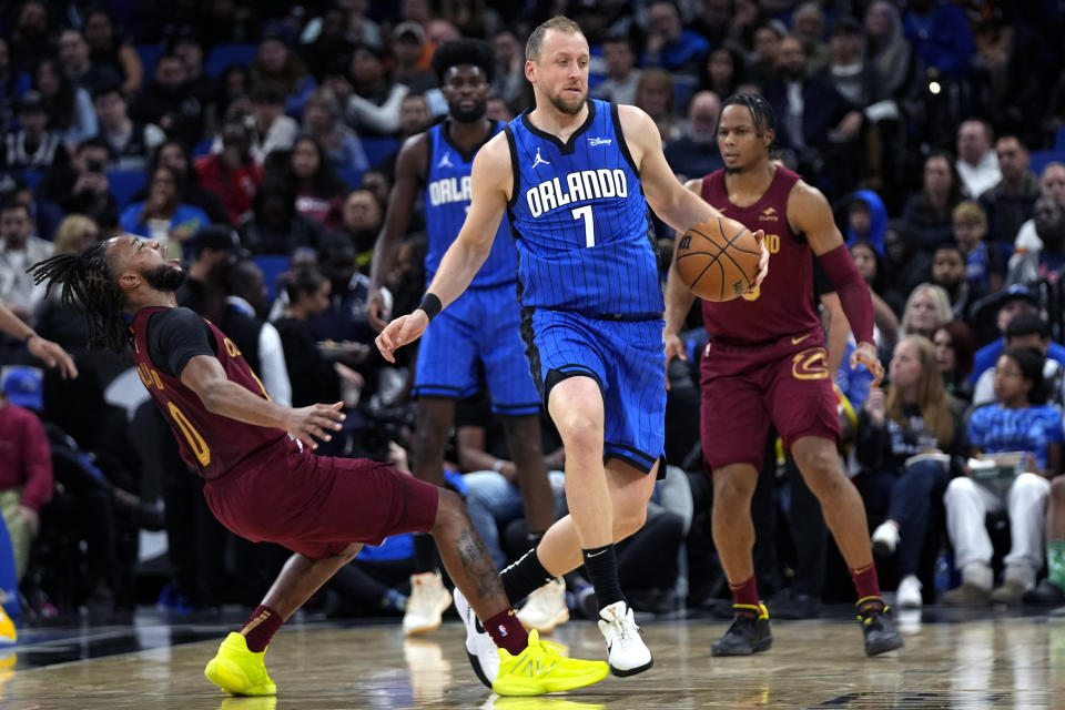 Cleveland Cavaliers guard Darius Garland, left, falls backward as he collides with Orlando Magic guard Joe Ingles (7) during the first half of an NBA basketball game, Monday, Dec. 11, 2023, in Orlando, Fla. (AP Photo/John Raoux)