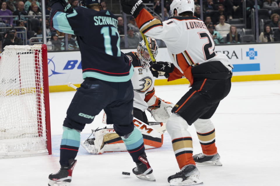 Seattle Kraken center Jaden Schwartz (17) tries to score as Anaheim Ducks goaltender John Gibson (36) and center Isac Lundestrom (21) defend during the first period of an NHL hockey game Tuesday, March 26, 2024, in Seattle. (AP Photo/Jason Redmond)