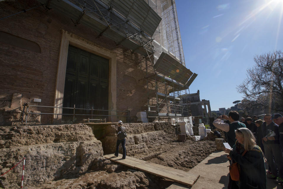 Reporters wait to visit the underground chamber where a 1.4-meter (55-inch) wide sarcophagus and what appears to be an altar, dating back to the 6th Century B.C., were found, during an unveiling to media, at the ancient Roman Forum, in Rome, Friday, Feb. 21, 2020. Archaeologists believe the underground shrine, who's finding was announced earlier this week, was dedicated to Romulus, the founder of the ancient city. (AP Photo/Andrew Medichini)