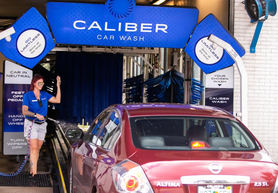 Caliber Car Wash employee Candace Cranston directs a driver into the car wash conveyor at the 4956 E. Silver Springs Blvd. location on Sept. 19.