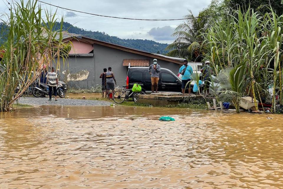 Several flood victims were seen wading through the floods in Hulu Langat, December 19, 2021. — Picture by Hari Anggara