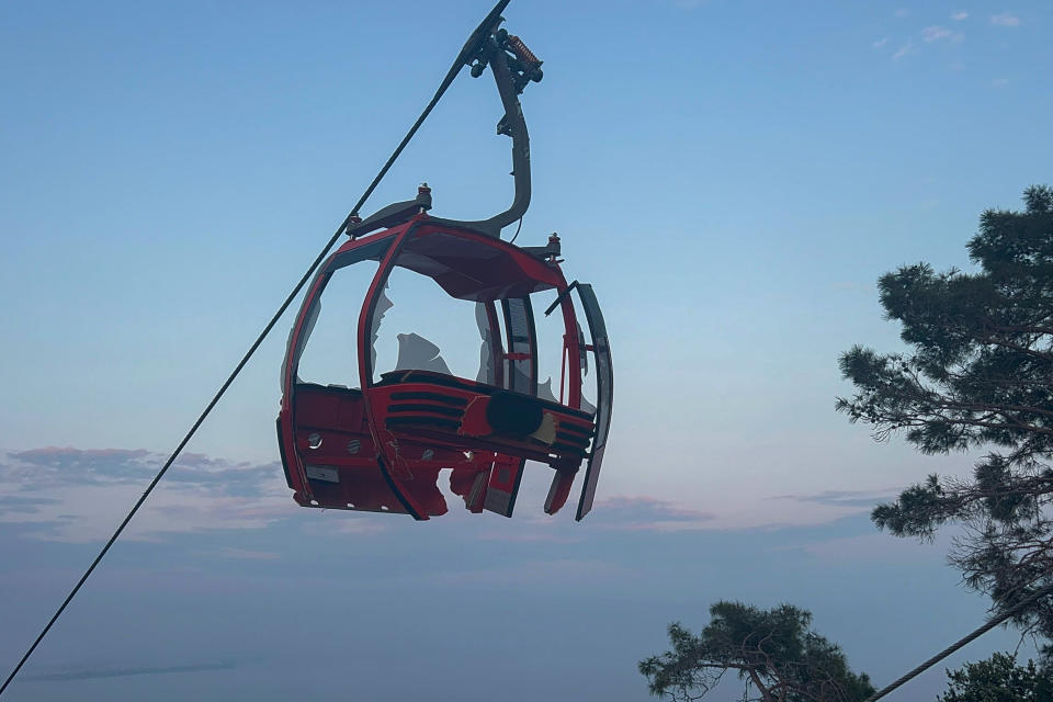 A severely damaged cabin of a cable car transportation system is seen outside Antalya, southern Turkey, Friday, April 12, 2024. At least one person was killed and several injured Friday when a cable car pod in southern Turkey hit a pole and burst open, sending the passengers plummeting to the mountainside below, officials and local media said. Scores of other people were left stranded late into the night after the entire cable car system came to a standstill. (Dia Images via AP)