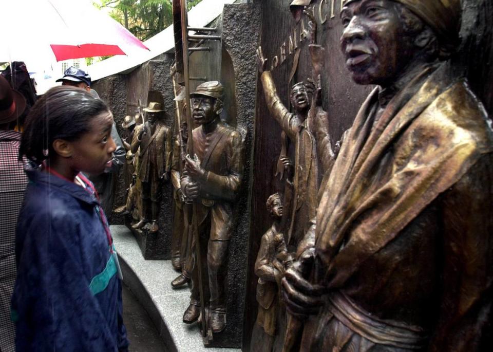 The South Carolina African American History Monument, sculpted by Ed Dwight, was dedicated March 29, 2001. Here, 13-year-old Ashley Canada, of Columbia examines the Emancipation section of the monument.