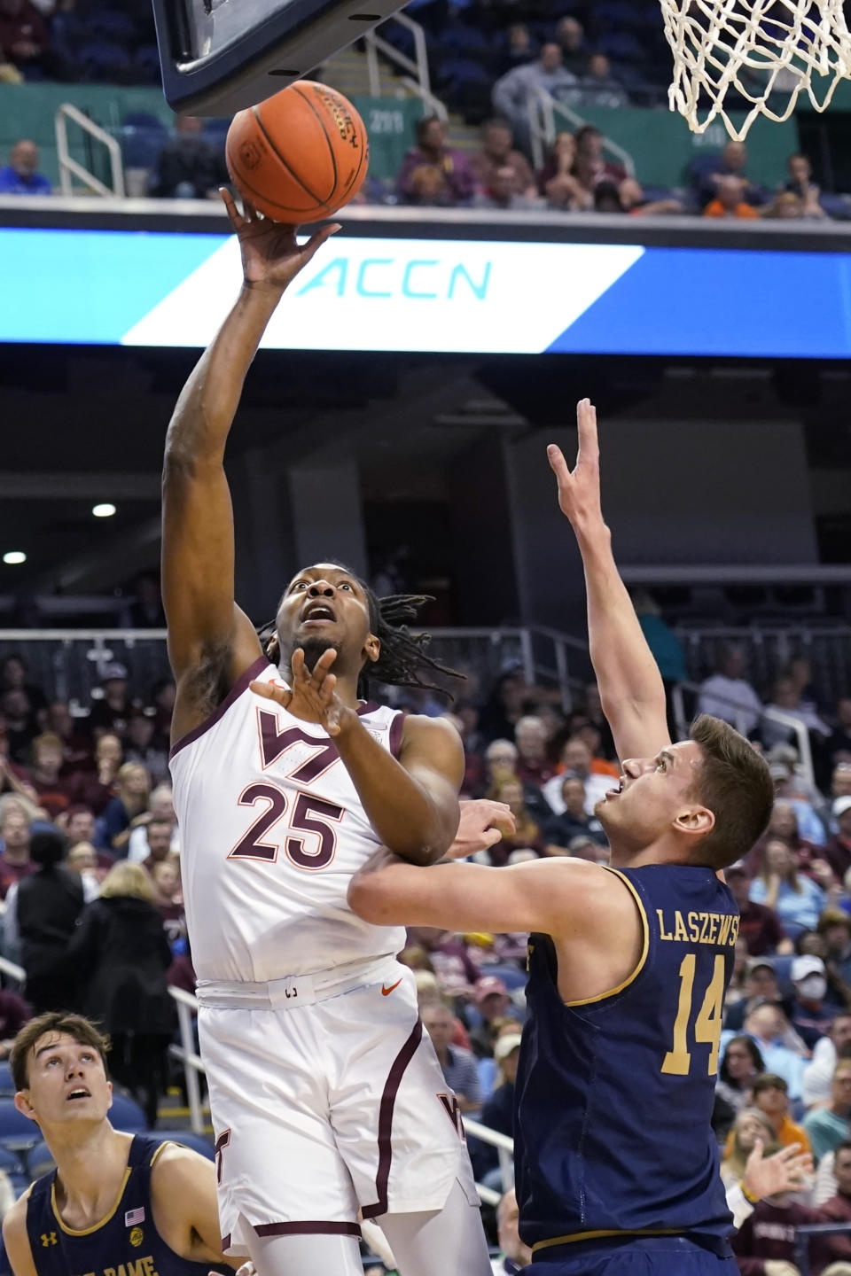 Virginia Tech forward Justyn Mutts (25) shoots next to Notre Dame forward Nate Laszewski (14) during the first half of an NCAA college basketball game at the Atlantic Coast Conference men's tournament in Greensboro, N.C., Tuesday, March 7, 2023. (AP Photo/Chuck Burton)