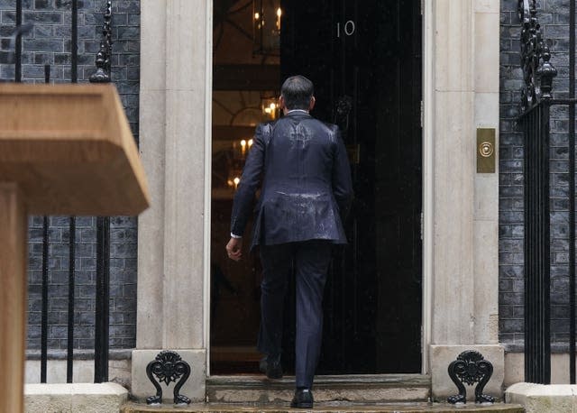 Prime Minister Rishi Sunak, soaked by rain, walks back into No 10 Downing Street