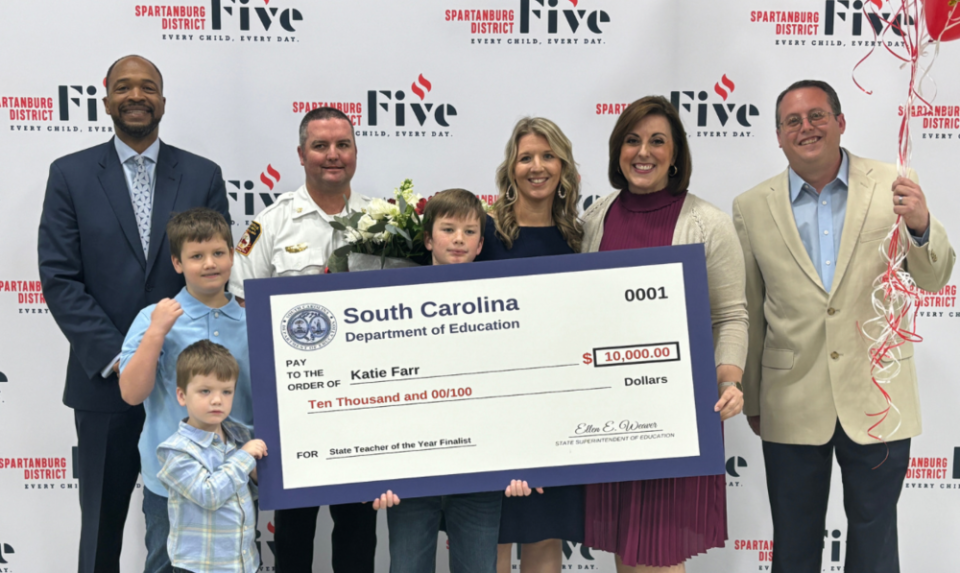 Katie Farr, a first-grade teacher at Wellford Academy of Science and Technology in Wellford and SC Teacher of the Year finalist, holds her $10,000 check she received from the SC Department of Education.