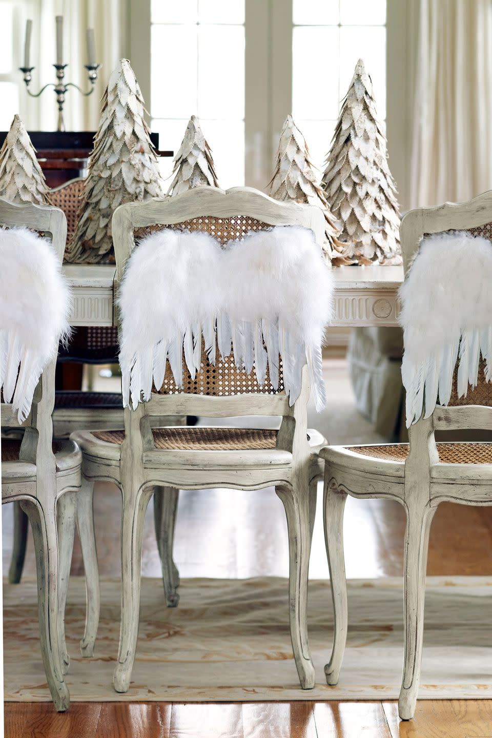 <p>A row of birch-bark trees makes for a simple yet stunning centerpiece. Dining chairs get into the holiday spirit with angel wings.</p><p><a class="link " href="https://go.redirectingat.com?id=74968X1596630&url=https%3A%2F%2Fwww.potterybarn.com%2Fproducts%2Flit-natural-glitter-birch-tree%2F&sref=https%3A%2F%2Fwww.countryliving.com%2Fdiy-crafts%2Fg644%2Fchristmas-tables-1208%2F" rel="nofollow noopener" target="_blank" data-ylk="slk:Shop Now;elm:context_link;itc:0;sec:content-canvas">Shop Now</a></p>