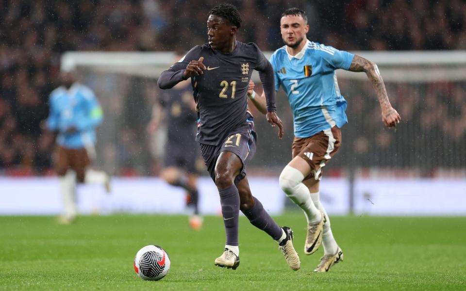 Kobbie Mainoo of England runs with the ball whilst under pressure from Zeno Debas