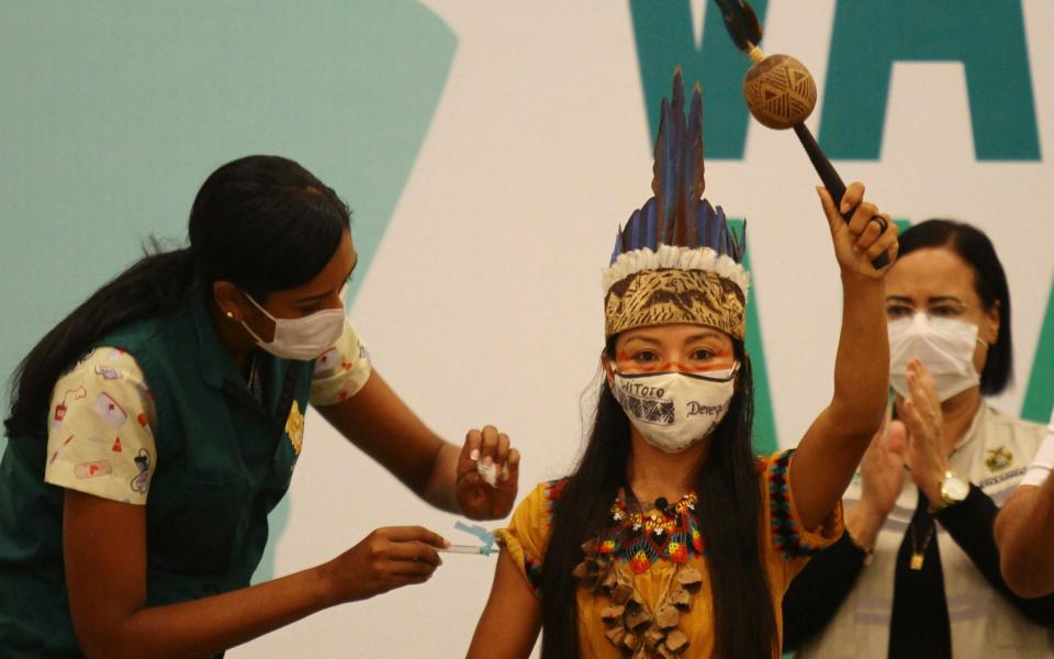 Healthcare worker Vanda Ortega, from the Witoto Indigenous group and dressed in traditional clothing, is the first woman to receive the vaccine produced by China's Sinovac - AP