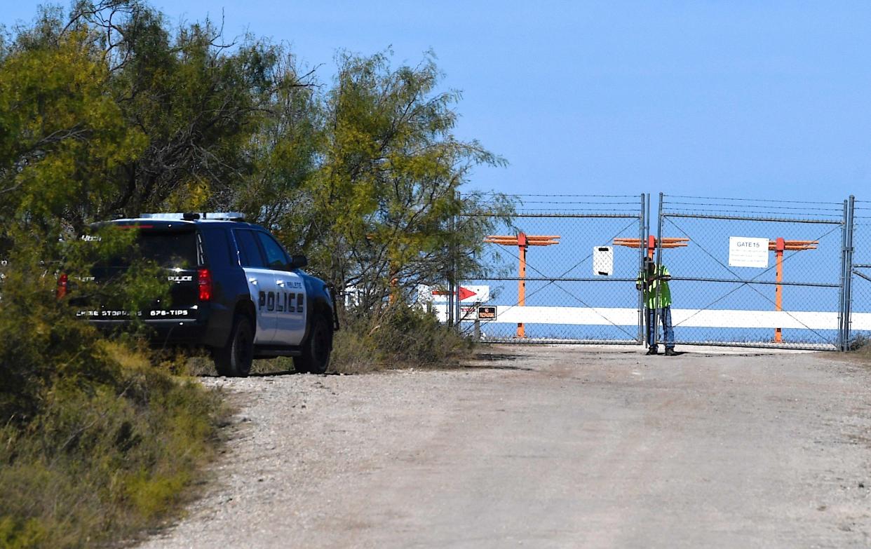 A man locks a gate near the 1600 block of East Industrial Boulevard into Abilene Regional Airport after a small plane crash was reported in the area Monday.