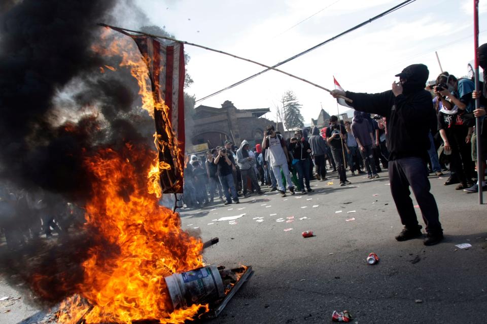 A protester lights a fire during a demonstration in Santiago on September 8, 2013, ahead of the 40th anniversary of the military coup that overthrew President Salvador Allende.