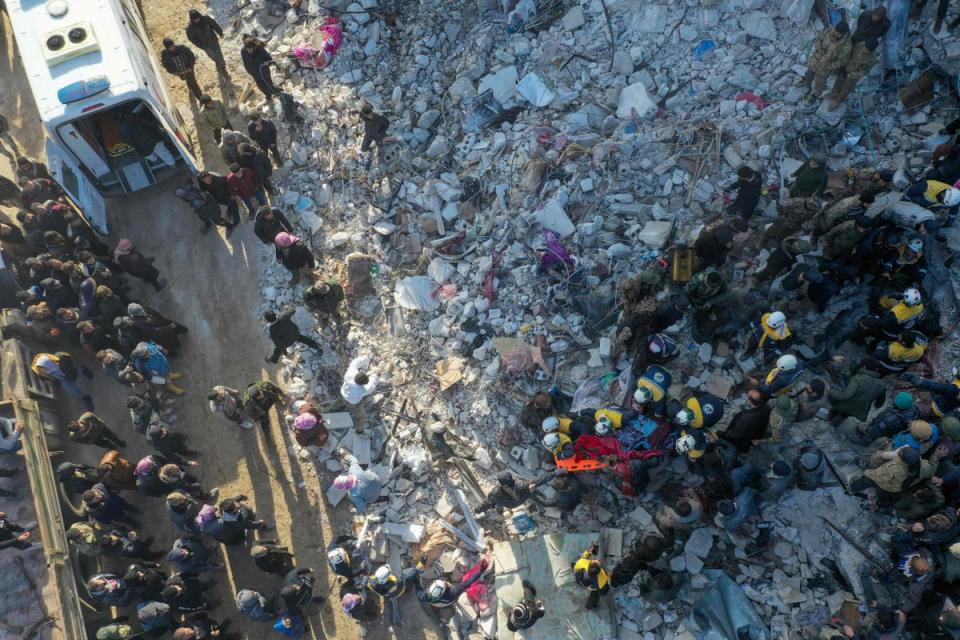 An aerial picture shows rescuers searching the rubble of buildings for casualties and survivors in the village of Besnaya in Syria’s rebel-held northwestern Idlib province at the border with Turkey  following an earthquake (AFP via Getty Images)