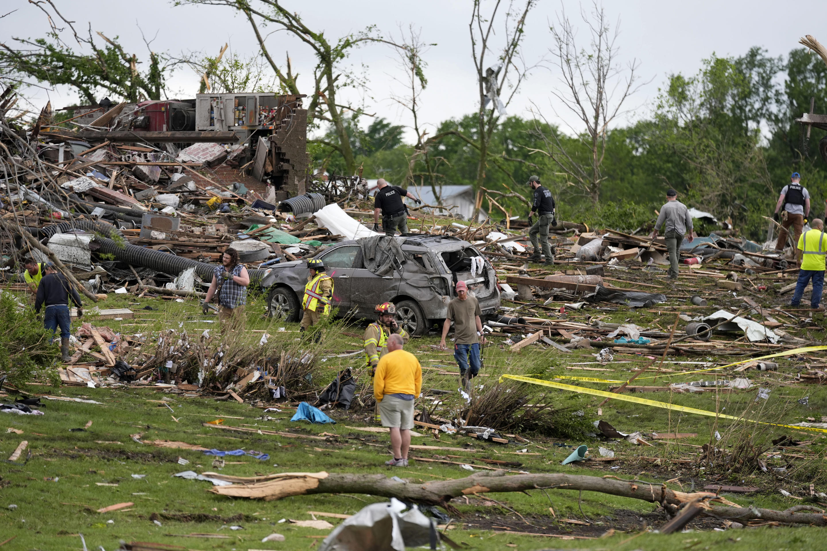 Workers search through the remains of tornado-damaged homes on Tuesday in Greenfield, Iowa.