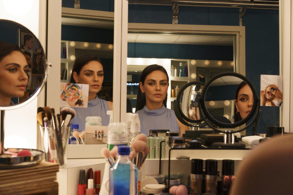 Mila Kunis stars inLuckiest Girl Alive. Still from film as woman applies makeup in front of a vanity mirror
