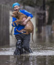 <p>Lance Lawson carries his dog Kawi, a 9-year-old pitbull, away from his flooded home Wednesday, Feb. 21, 2018, in South Bend, Ind. (Photo: Robert Franklin/South Bend Tribune via AP) </p>