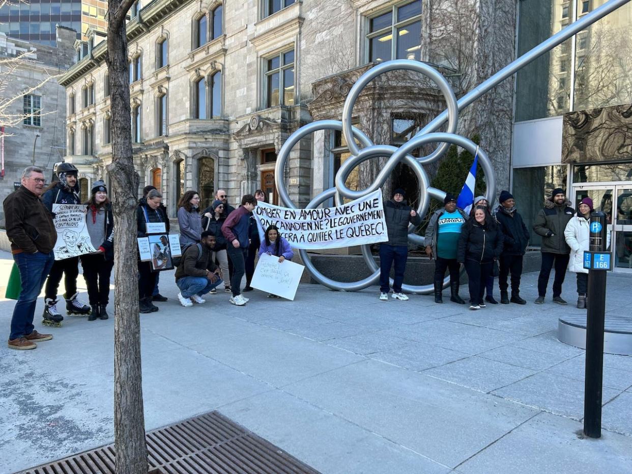 Protesters gathered in front of Quebec Premier François Legault’s office in Montreal Sunday afternoon demanding Quebec speed up its processing times for family reunification to match the rest of Canada.  (Rowan Kennedy/CBC - image credit)