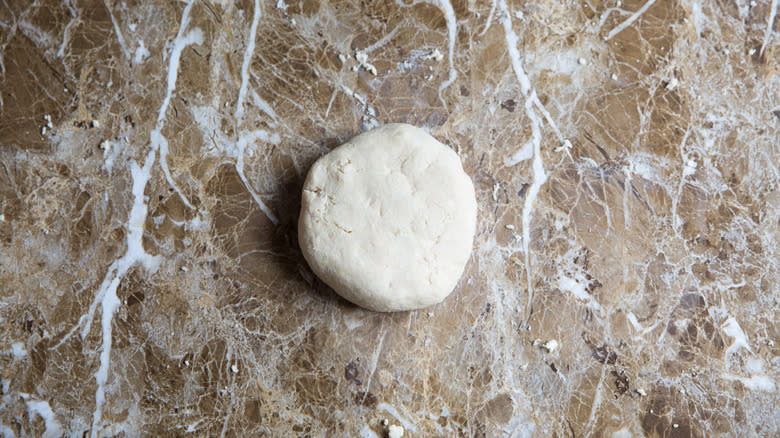 flattened dough ball on counter 