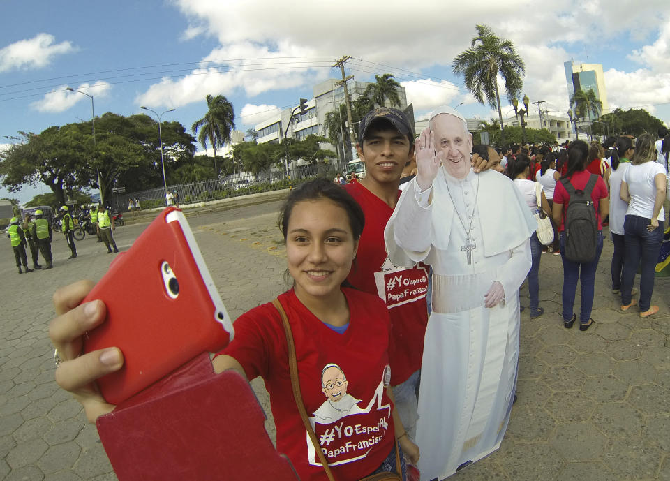SANTA CRUZ, BOLIVIA - JUNE 10:  A young woman and a young man take a selfie with a cutout of Pope Francis during the Pope Francis official video film shooting on June 10, 2015 in Santa Cruz, Bolivia.  Bolivia is now preparing for the visit of Pope Francis from July 8th to July 10th. (Photo by Amanecer Tedesqui/LatinContent/Getty Images)