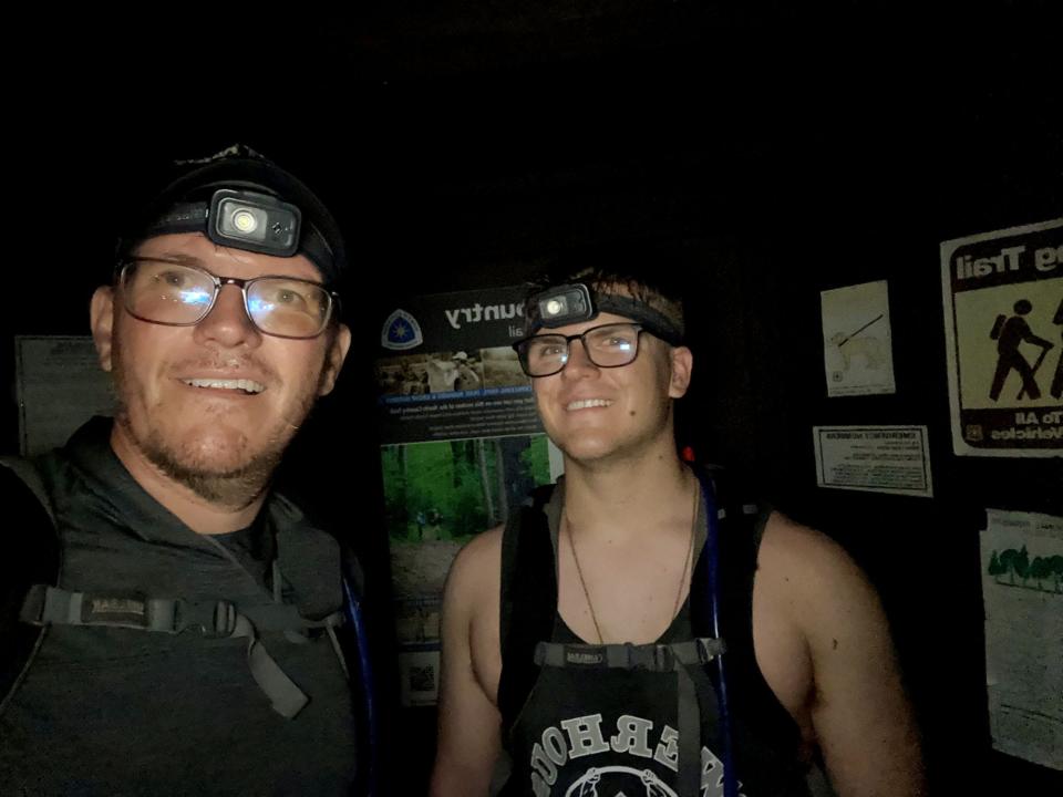 Jim Pool, left and his son, Elijah, at about 11:30 p.m., the end their 52-mile hike in the Manistee National Forest in the northern part of the Lower Peninsula.