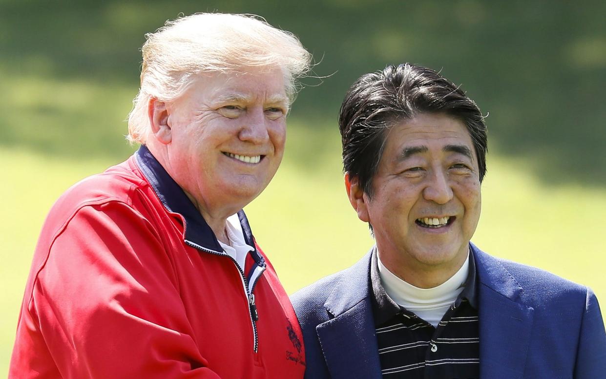 US President Donald Trump and Shinzo Abe, Japan's prime minister, pose for photographs at Mobara Country Club in Chiba Prefecture - EPA