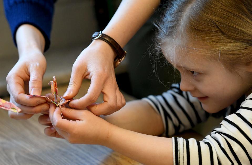 Ellie Sheckler, 4, takes a look at an origami bird Wednesday, March 29, 2023, during a visit from a group of Japanese students hosted by Mount Union. The visitors stopped to teach preschool students at Union Avenue United Methodist Church how to do origami.