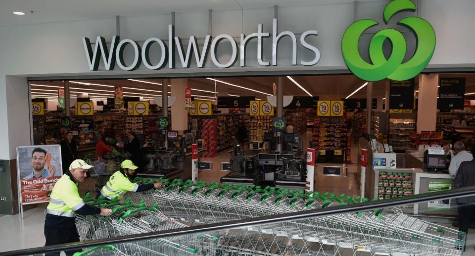 Woolworths staffers push empty trolleys outside supermarket