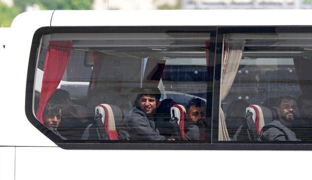 A group of people thought to be migrants are driven away from the Border Force compound in Dover