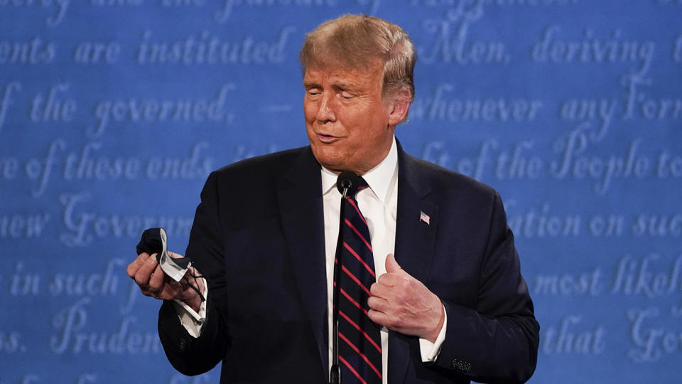 President Donald Trump holds out his face mask during the first presidential debate Tuesday, Sept. 29, 2020, at Case Western University and Cleveland Clinic, in Cleveland, Ohio. (Julio Cortez/AP)