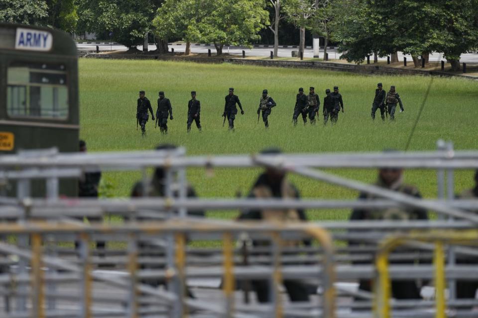 Army soldiers arrive to secure surroundings of the parliament in Colombo, Sri Lanka, Thursday, July 14, 2022. Sri Lankan protesters began to retreat from government buildings they had seized and military troops reinforced security at the Parliament on Thursday, establishing a tenuous calm in a country in both economic meltdown and political limbo. (AP Photo/Eranga Jayawardena)