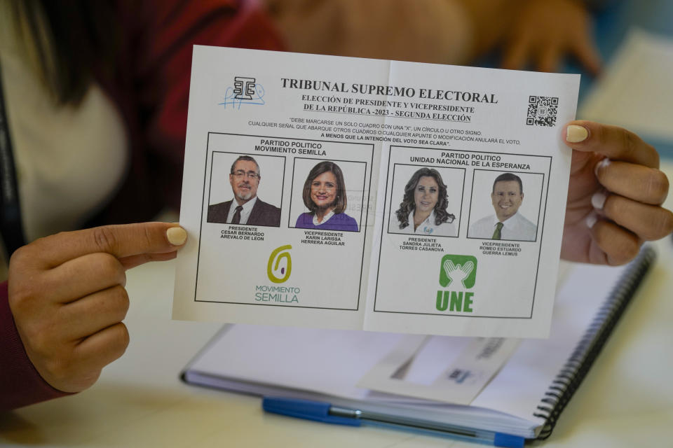 Una funcionaria electoral muestra la boleta con los candidatos para la segunda vuelta de las elecciones presidenciales en Ciudad de Guatemala, el domingo 20 de agosto de 2023. (Foto AP/Moisés Castillo)