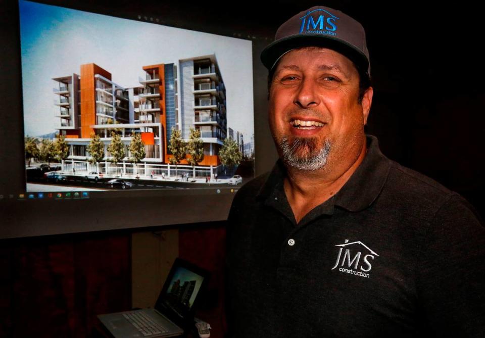 James Sexton, owner of JMS Construction, stands in front of a projected artist rendering of an eight-story 55+ rental community he hopes to build at Osprey Pointe.