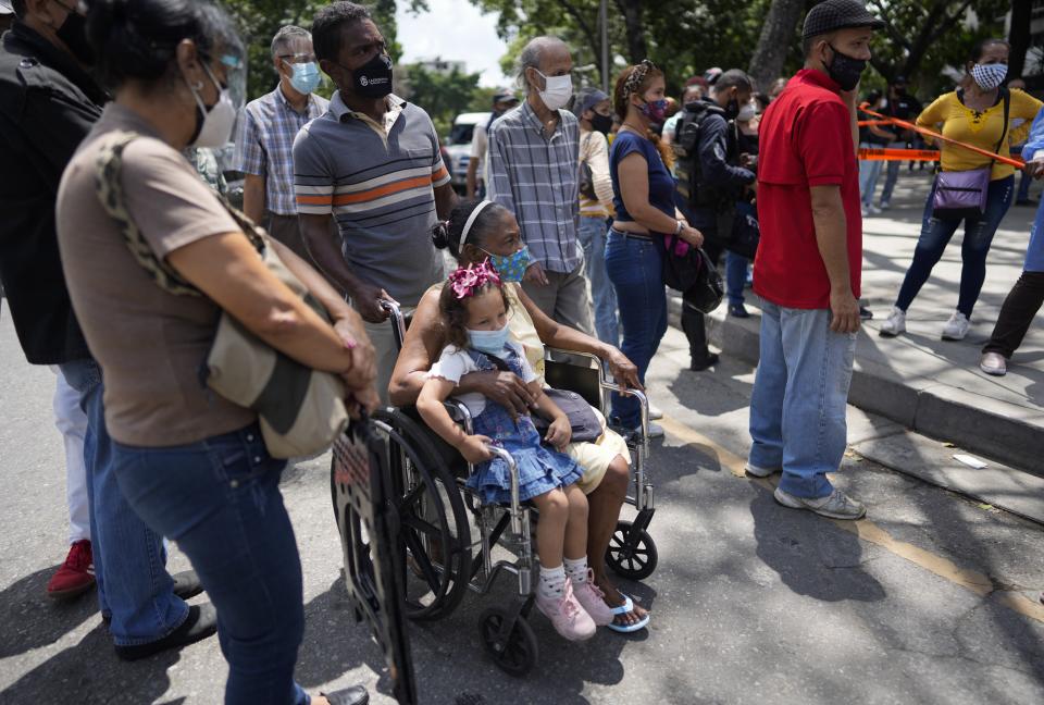 Residents gather outside a vaccination center looking to be inoculated with a second dose of the Sputnik V COVID-19 vaccine, in Caracas, Venezuela, Thursday, Sept. 16, 2021. The Venezuelan government is beginning rollouts of second doses following months of delays. (AP Photo/Ariana Cubillos)