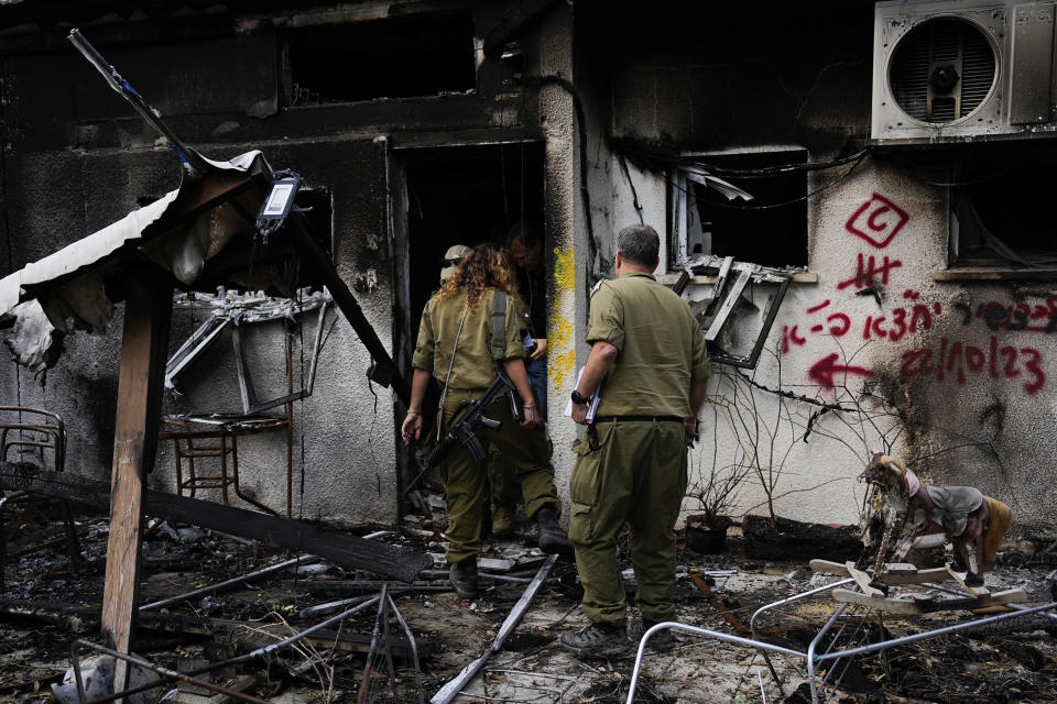 Israeli soldiers inspect houses destroyed by Hamas militants Kibbutz Nir Oz, southern Israel, Tuesday, Nov. 21, 2023, The kibbutz was overrun by Hamas militants from the nearby Gaza Strip on Oct. 7, when they killed and captured many Israelis. (AP Photo/Ohad Zwigenberg)