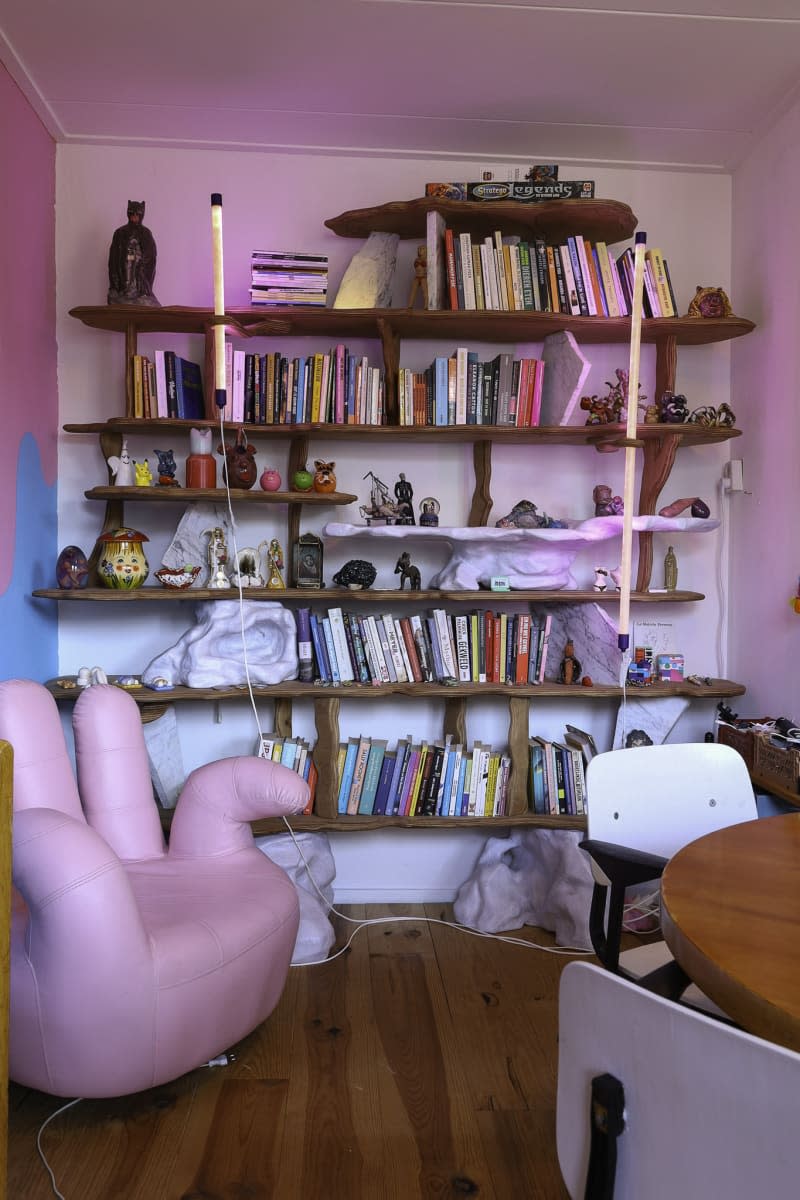 dining room with wood bookshelves, blue and pink wall, and pink hand chair