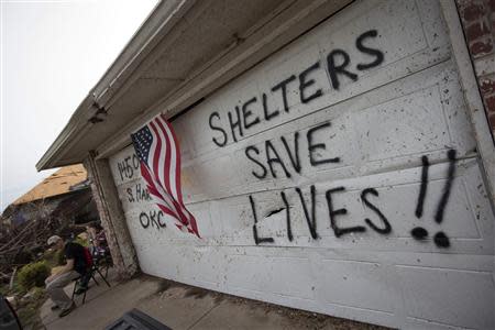 Residents spray paint a message on their garage door in Moore, Oklahoma, three days after the Oklahoma City suburb was left devastated by a tornado in this file photo from May 23, 2013. REUTERS/Adrees Latif/Files