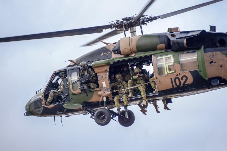 Australian Army soldiers from the 2nd Commando Regiment prepare to insert into the High Range training area near Townsville, Queensland, on board a 6th Aviation Regiment Black Hawk helicopter during Exercise Talisman Sabre 2019. <em>COMMONWEALTH OF AUSTRALIA, DEPARTMENT OF DEFENSE</em>