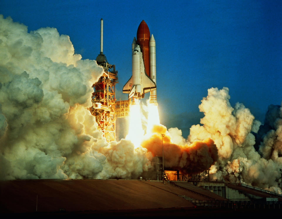 Space shuttle launch with billowing smoke at liftoff from launchpad